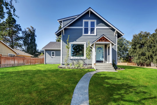 Blue clapboard siding house with grass filled front yard.