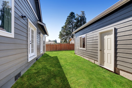 Blue Siding House With Matching Detached Garage