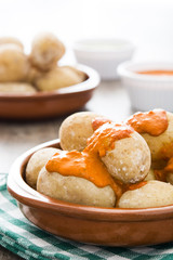 Canarian potatoes (papas arrugadas) with mojo sauce on wooden table

