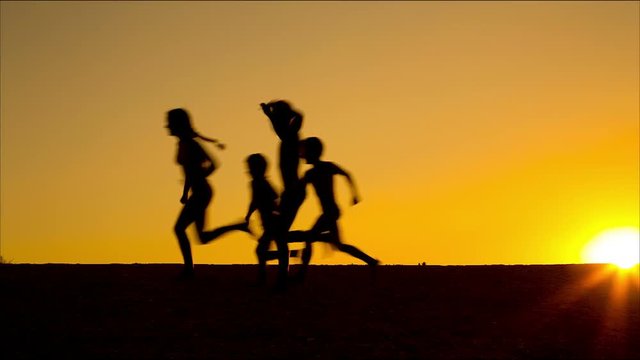 silhouette of running kids against sunset