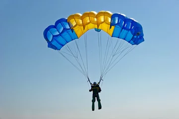 Photo sur Plexiglas Sports aériens Vol en parapente sur parachute coloré dans un ciel bleu clair lors d& 39 une belle journée d& 39 été ensoleillée. Mode de vie actif, loisirs extrêmes