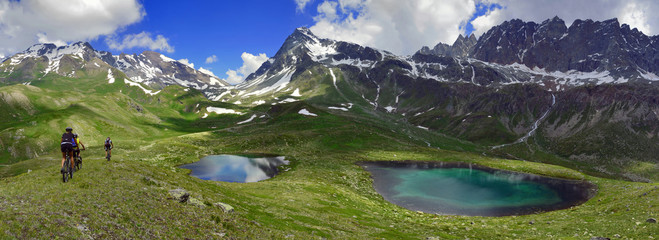 Fototapeta premium Rowerzyści w Alpach, między jeziorami i górami