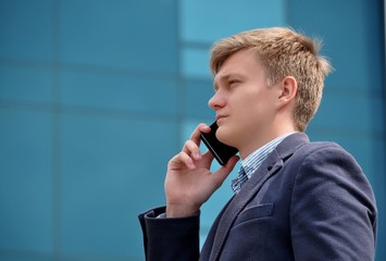 Businessman talking on a smartphone near a modern building