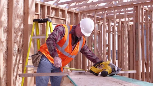 Portrait of construction worker measuring wood