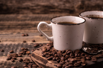 coffee cup with roasted  beans on wooden background