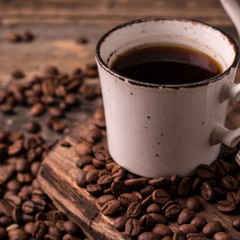 coffee cup with roasted  beans on wooden background