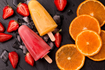 refreshing fruit popsicle lollies on wooden table with berries and fruits