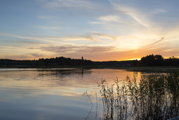 Colorful evening by the lake in Finland. An image of a beautiful sunset on a summer night.