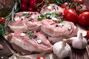 Fresh butcher cut meat assortment garnished with fresh rosemary on wooden table