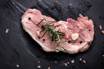 Fresh butcher cut meat assortment garnished with fresh rosemary on wooden table