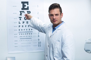 Naklejka na ściany i meble Optometrist pointing at eye chart