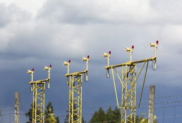 Airport landing lights against a dramatic sky with clouds.