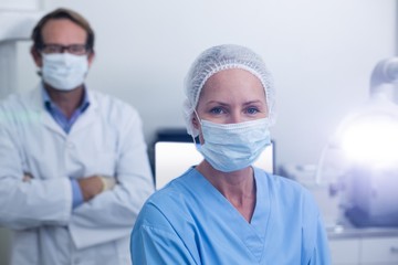 Fototapeta na wymiar Portrait of dentist and dental assistant wearing surgical mask