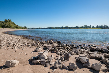 Kieselstrandufer mit Steinbl&ouml;cken und B&auml;umen, Flusslandschaft
