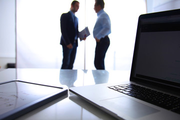 Obraz premium Focus on laptop the table. Blurred people background