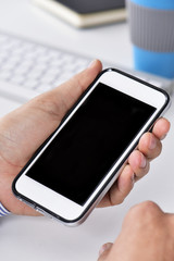 man at his office with a blank smartphone
