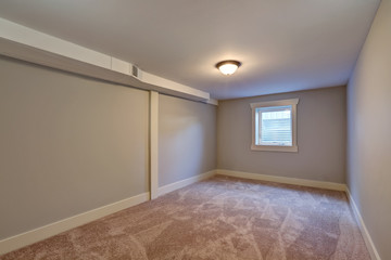 Empty room with beige carpet floor and small window