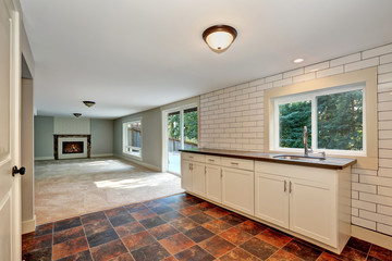 Empty room with a washbasin cabinet and brown tile floor.