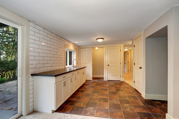 Empty room with a washbasin cabinet and brown tile floor. Northwest, USA
