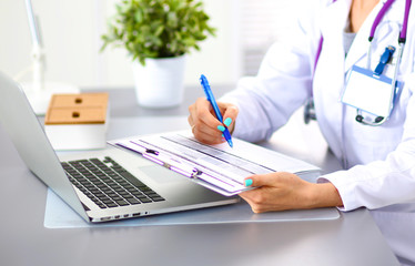 Portrait of young woman doctor in white coat at computer