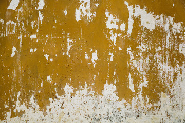 Old rusty metal surface is covered with several layers of peeling paint of different colors. background