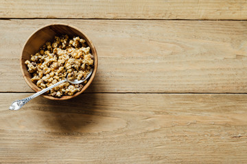 Homemade oatmeal granola in wooden bowl