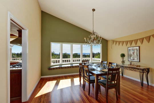Elegant dining room with contrast olive wall and hardwood floor