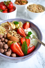 smoothie in a bowl for breakfast with yogurt, strawberries, oatmeal, almonds and banana