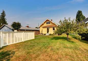 Fototapeta na wymiar Backyard view of yellow siding craftsman house.