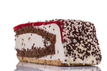 Ein Stück Kirschsahnetorte auf spiegelndem Untergrund mit Schokostreuseln