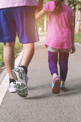 Fototapeta na wymiar Runners jogging close up of sport fitness running shoes and legs and shorts. Athletes, Father and daughter in outdoor workout training for health and fitness. soft focus
