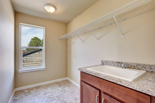 Empty laundry room interior with tile flooring