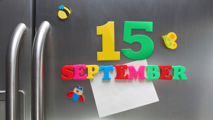September 15 calendar date made with plastic magnetic letters holding a note of graph paper on door refrigerator