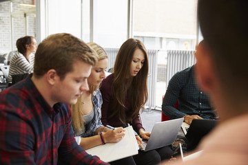 Group Of Students In Library Collaborating On Project