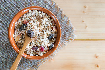 Serving muesli scattering of nuts on wooden table