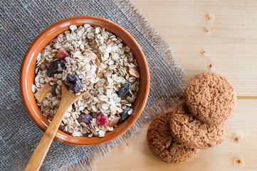 Serving muesli scattering of oat cookie on wooden table