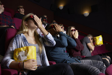 Naklejka premium Couple In Cinema Wearing 3D Glasses Watching Horror Film