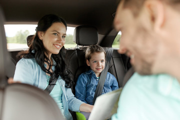 happy family with travel map driving in car