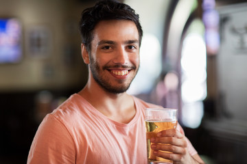 happy man drinking beer at bar or pub