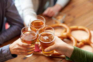 close up of hands clinking beer at bar or pub