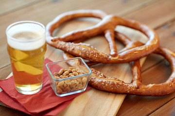 close up of beer, pretzels and peanuts on table