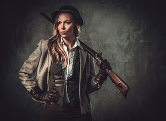 Lady with shotgun and hat from wild west on dark background. - obrazy, fototapety, plakaty