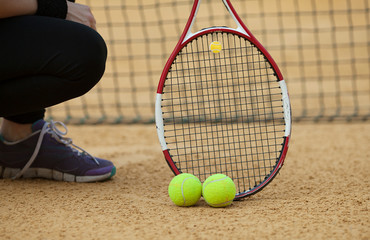tennis racket with ball on clay court