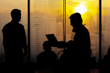 Businessmen in a sunset on the tallest building in Bangkok..