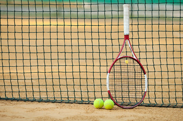 tennis racket with ball on clay court
