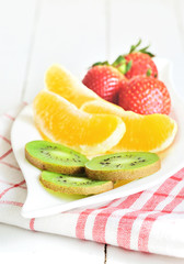 Bowl with fruit salad - pieces of orange, strawberry and kiwi