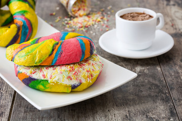 Colorful bagels with cheese and sprinkles on a wooden table

