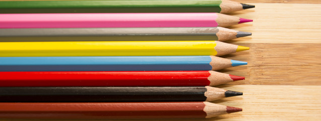 Colored pencils isolated on wooden background