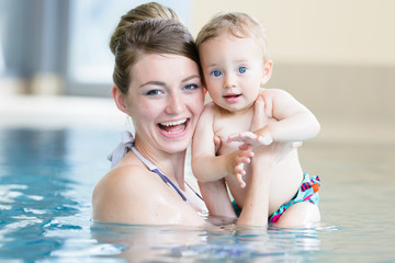 Mutter mit Ihrem neugeborenen Kind beim Babyschwimmen