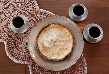 Cheesecake on a plate on wooden table and a three cup of coffee. Top view.
